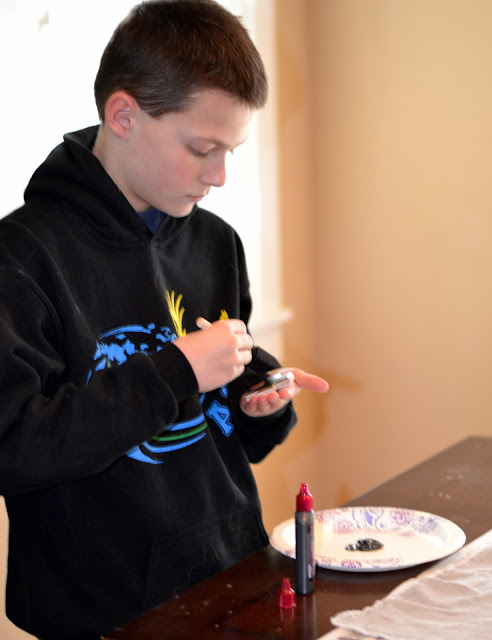 painting the rubber stamp to create a handmade swaddle blanket painting the stamp