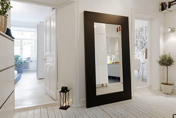 large glass mirror with brown frame leaning against the kitchen wall